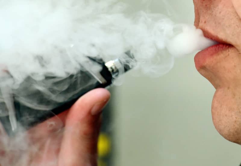 A person exhaling whilst using a vaping product. Spending a lot of time on social media could increase the chances of teenagers taking up smoking or vaping, according to a study. Nicholas.T.Ansell/PA Wire/dpa