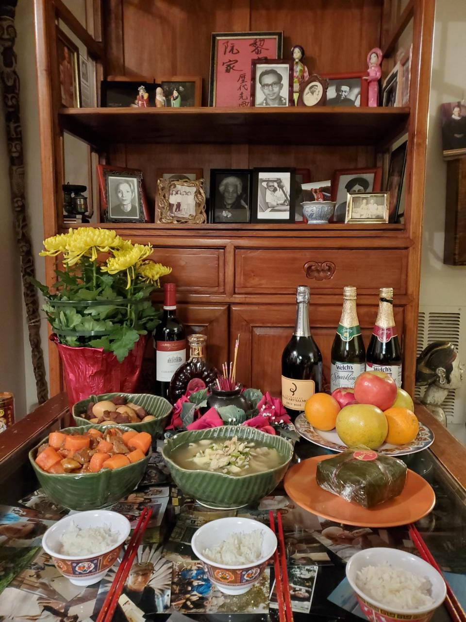 The square “banh chung,” front on the orange plate, is a major Tet dish offered on Thuan Le Elston’s family altar for Lunar New Year’s Eve.