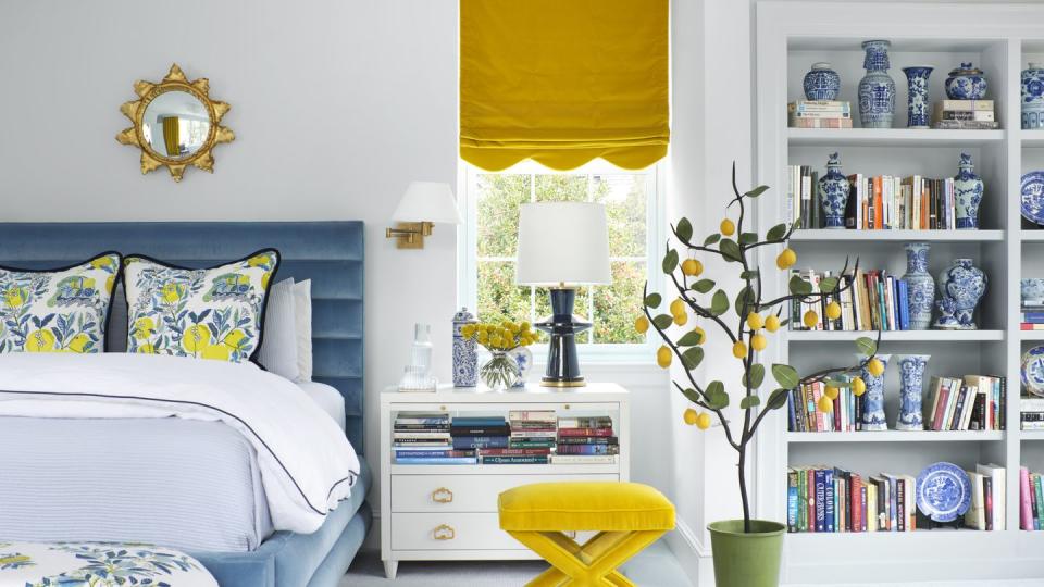 bedroom, blue bed, floral bench seat, yellow stool, yellow curtains