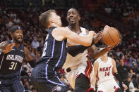 Orlando Magic forward Franz Wagner (22) fouls Miami Heat center Bam Adebayo (13) during the first half of a an NBA basketball game, Monday, Oct. 25, 2021, in Miami. (AP Photo/Marta Lavandier)