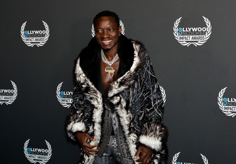 Michael Blackson wearing fur jacket