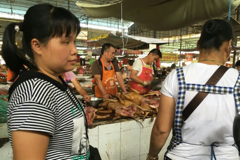 Vendors stand behind a pile of dog meat at the Nanqiao market in Yulin