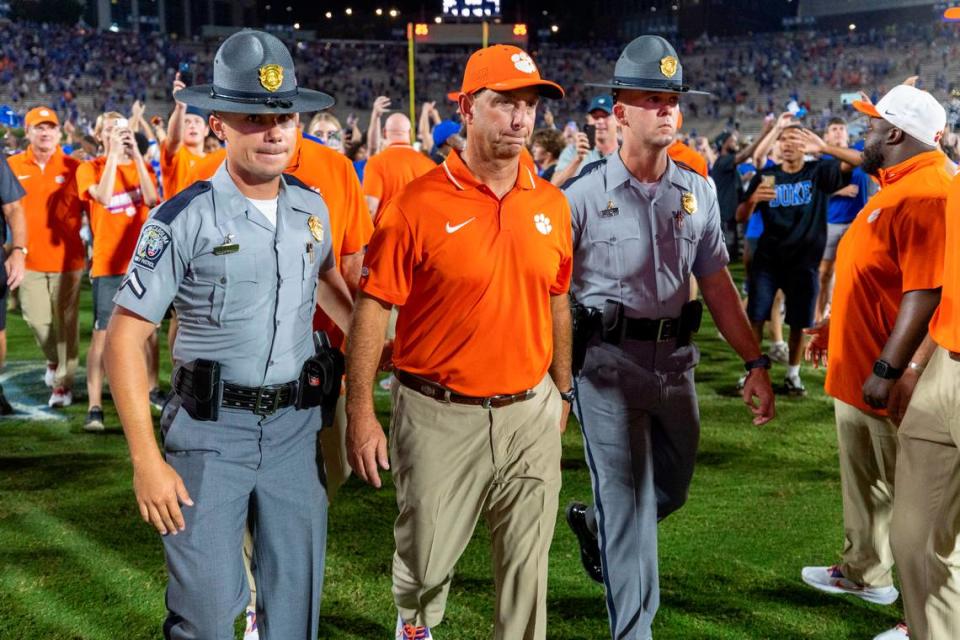 Clemson coach Dabo Swinney is escorted off the field as Duke fans celebrate their 28-7 victory over Clemson on Monday, September 4, 2023 at Wallace Wade Stadium Stadium in Durham, N.C.