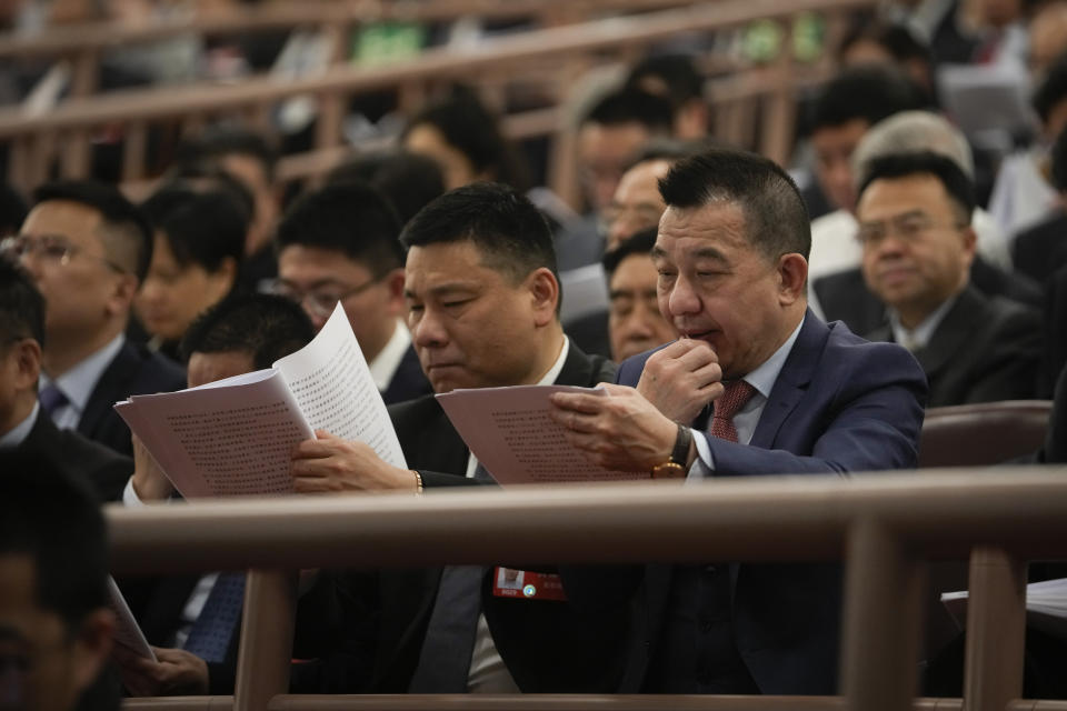 Delegates read the opening remark by Chinese Premier Li Qiang during the opening session of the National People's Congress (NPC) at the Great Hall of the People in Beijing, China, Tuesday, March 5, 2024. (AP Photo/Andy Wong)