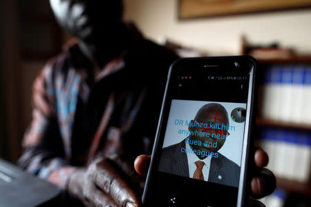 Simon Munzu, a former UN official, who is campaigning for peace in the Anglophone regions of Cameroon, shows a threat message posted against him on social media by separatists during an interview with Reuters in Yaounde, Cameroon October 3, 2018. Picture taken October 3, 2018. REUTERS/Zohra Bensemra