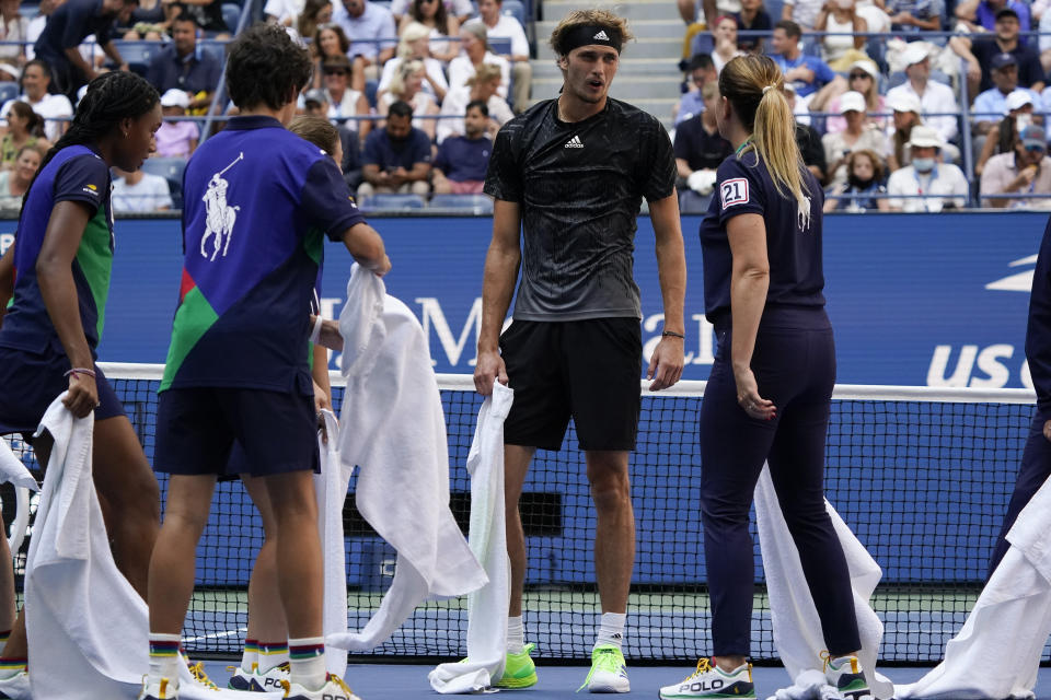 Alexander Zverev, of Germany, talks with court attendants as they dry liquid off the court during the quarterfinals of the US Open tennis championships against Lloyd Harris, of South Africa, Wednesday, Sept. 8, 2021, in New York. (AP Photo/Elise Amendola)