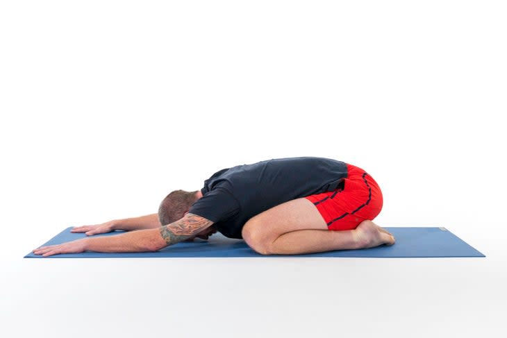 A person demonstrates Child's Pose (Balasana) in yoga