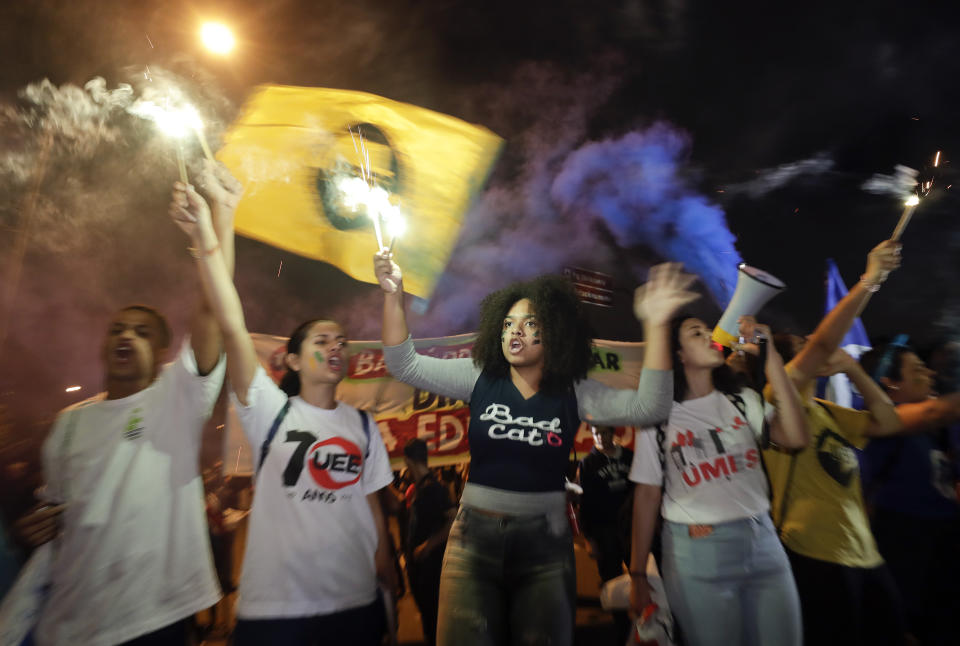 Students light flares as they protest against a massive cut in the education budget imposed by the administration of Brazilian President Jair Bolsonaro in Sao Paulo, Brazil, Wednesday, May 15, 2019. Federal education officials this month announced budget cuts of $1.85 billion for public education, part of a wider government effort to slash spending. (AP Photo/Andre Penner)