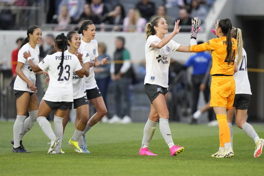 Bay FC Kayla Lynne Sharples (27), center, celebrates with goalkeeper Lysianne Proulx (44) after defeating Angel City FC during an NWSL soccer match, Sunday, March 17, 2024, in Los Angeles. Bay FC won the match 1-0. (AP Photo/Doug Benc)