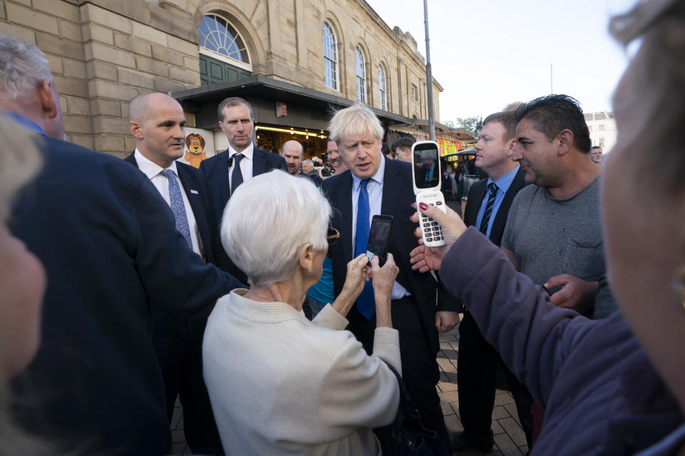 Britain's Prime Minister Boris Johnson poses for selfies with members of the public during a visit to Doncaster Market, in Doncaster, Northern England, Friday Sept. 13, 2019. Johnson will meet with European Commission president Jean-Claude Juncker for Brexit talks Monday in Luxembourg. The Brexit negotiations have produced few signs of progress as the Oct. 31 deadline for Britain’s departure from the European Union bloc nears. ( AP Photo/Jon Super)