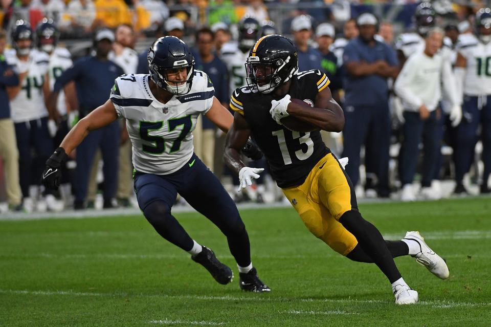 PITTSBURGH, PA - AUGUST 13: Miles Boykin #13 of the Pittsburgh Steelers runs up field after a catch under pressure from Cody Barton #57 of the Seattle Seahawks in the second quarter during a preseason game at Acrisure Stadium on August 13, 2022 in Pittsburgh, Pennsylvania. (Photo by Justin Berl/Getty Images)