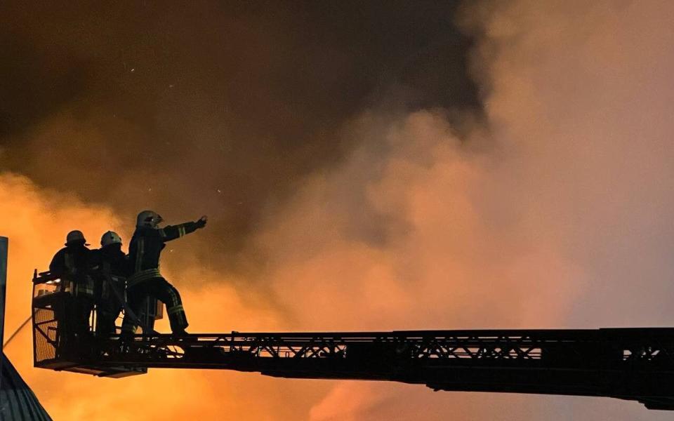 Firemen are seen attempting to extinguish flames sparked by a Russian drone strike on an Odesa apartment block