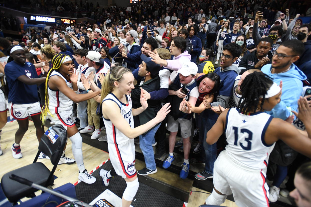 Christyn Williams, Paige Bueckers and Aaliyah Edwards of the UConn Huskies celebrate with fans after their win over UCF during the second round of the 2022 NCAA women's basketball tournament. (Sean Elliot/NCAA Photos via Getty Images)