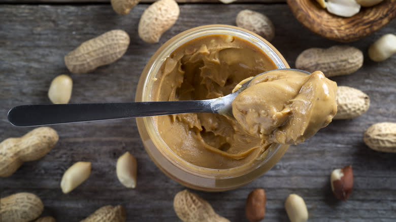 peanut butter in spoon propped on jar