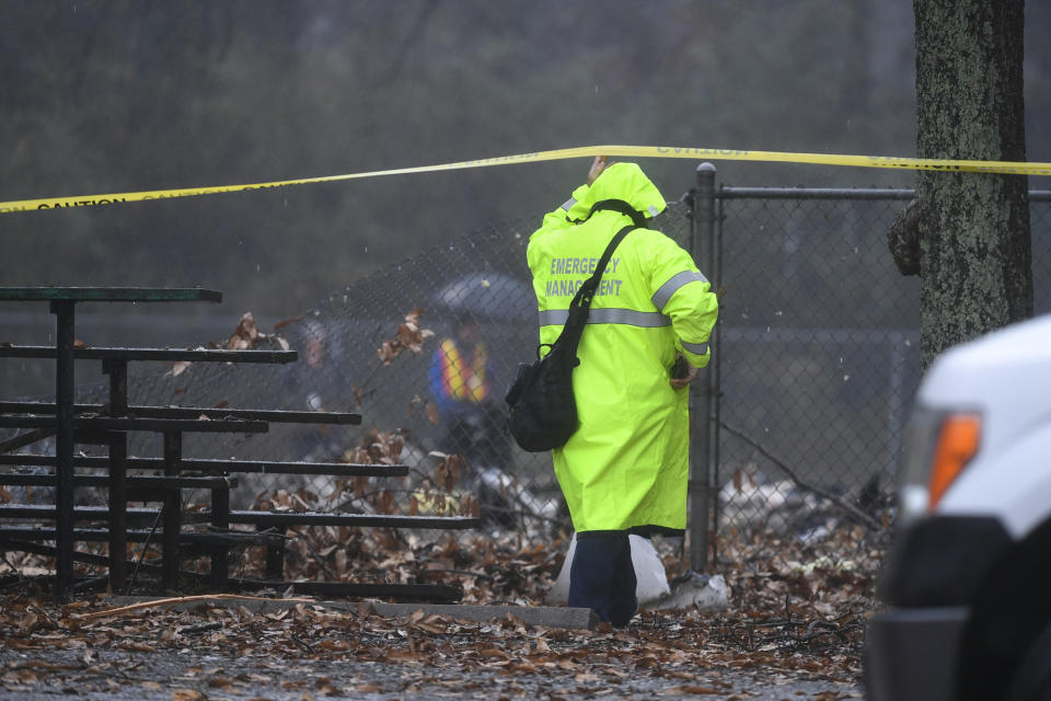 An investigator works the scene of a small plane crash in a city park which killed all on board, Thursday, Dec. 20, 2018, in northwest Atlanta. (AP Photo/John Amis)