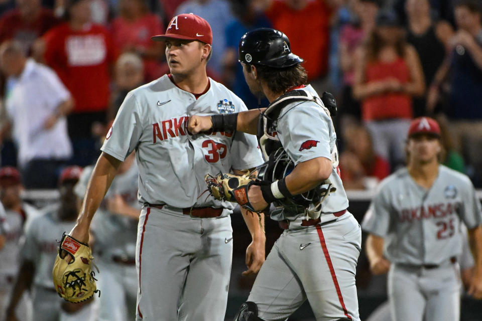 Jun 22, 2022; Omaha, NE, USA; Arkansas Razorbacks catcher Michael Turner (12) celebrates with pitcher Zack Morris (32) after defeating at Charles Schwab Field. Mandatory Credit: Steven Branscombe-USA TODAY Sports