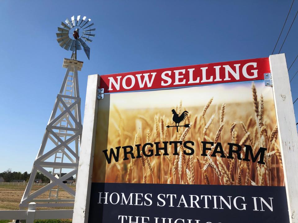 An authentic farm windmill shipped from Iowa stands at the corner of farmland at the Wrights Farm subdivision in Columbia County.