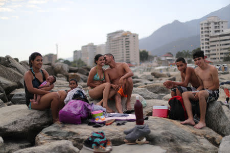 Leonel Martinez, who works as soldier, kisses his girlfriend as they spend a day at Coral beach in La Guaira near Caracas, Venezuela, March 23, 2019. "It's a way to think about something besides what is happening in the country," said Martinez. "It's not something you can do every day, because of the situation in the country." REUTERS/Ivan Alvarado