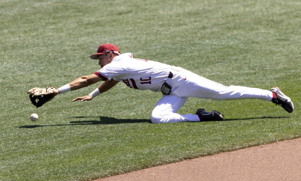 North Carolina State's Adam Crampton (10) dives in vain for a single hit by Stanford's Tommy Troy (12) in the fourth inning in the opening baseball game of the College World Series, Saturday, June 19, 2021, at TD Ameritrade Park in Omaha, Neb. (AP Photo/Rebecca S. Gratz)