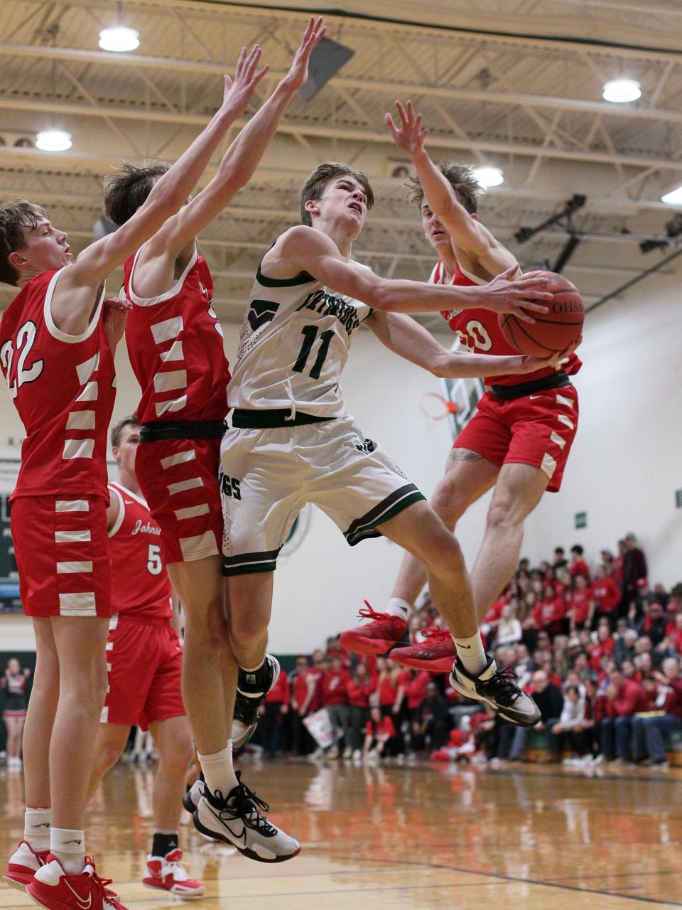 Northridge junior Carter Mallernee attempts to shoot a layup between Johnstown junior Brady Barb, from left, senior Cody Siegfried and senior Drew Brett on Friday, Feb. 3, 2023. Mallernee's 15 points led the host Vikings to a 53-46 victory, which clinched the Licking County League-Cardinal Division title, the program's first league championship.