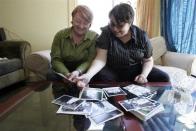 Emily Drennen (L) and Lindasusan Ulrich look over their wedding photos in their home in San Francisco, California June 11, 2008. For many California gays and lesbians, getting married is nothing new. They've done it more than once — to the same person. But as the state officially begins marrying same-sex couples, old hands say each time is different.