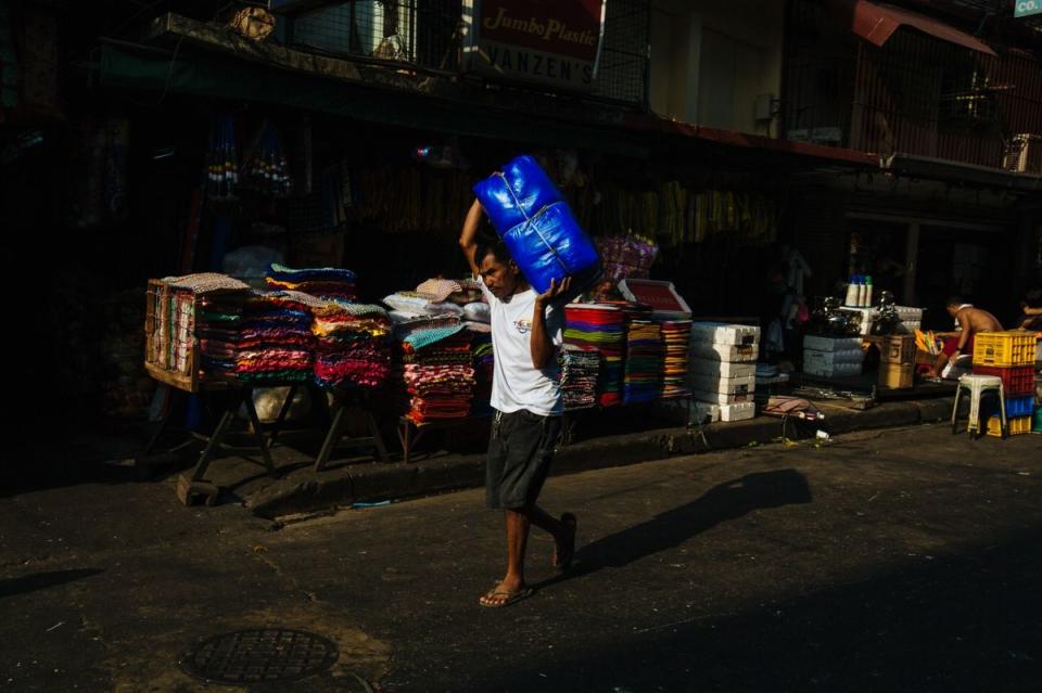 A laborer carries goods in the market district of Divisoria in Manila, the Philippines. (Photo: Getty Images)