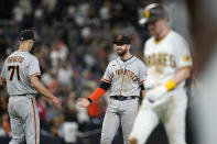 San Francisco Giants third baseman Evan Longoria, center, reacts with relief pitcher Tyler Rogers (71) after the Giants defeated the San Diego Padres 6-5 in a baseball game Tuesday, Sept. 21, 2021, in San Diego. (AP Photo/Gregory Bull)