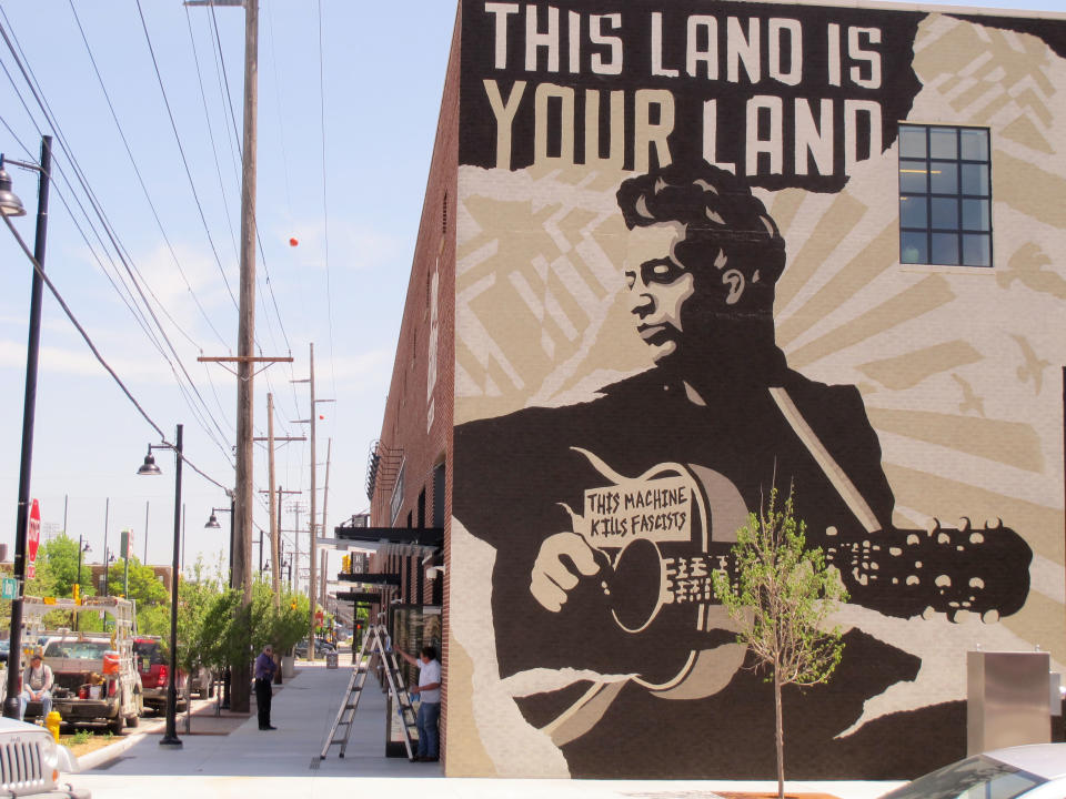 This April 25, 2013, photo shows workers put the finishing touches on the Woody Guthrie Center, which features a mural of the Oklahoma-born folk singer/songwriter, in downtown Tulsa. The center is set to open to the public on Saturday, April 27. (AP Photo/Justin Juozapavicius)