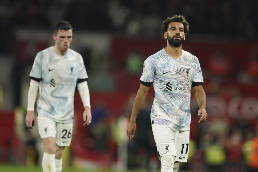 Mohamed Salá (derecha) y Andrew Robertson, su compañero en el Liverpool, se marchan de la cancha tras la derrota ante el Manchester United, el lunes 22 de agosto de 2022 (AP Foto/Dave Thompson)