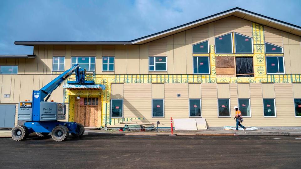 A workers walks past the front of the new Fawcett Elementary School on Friday, March 3, 2023, in Tacoma.