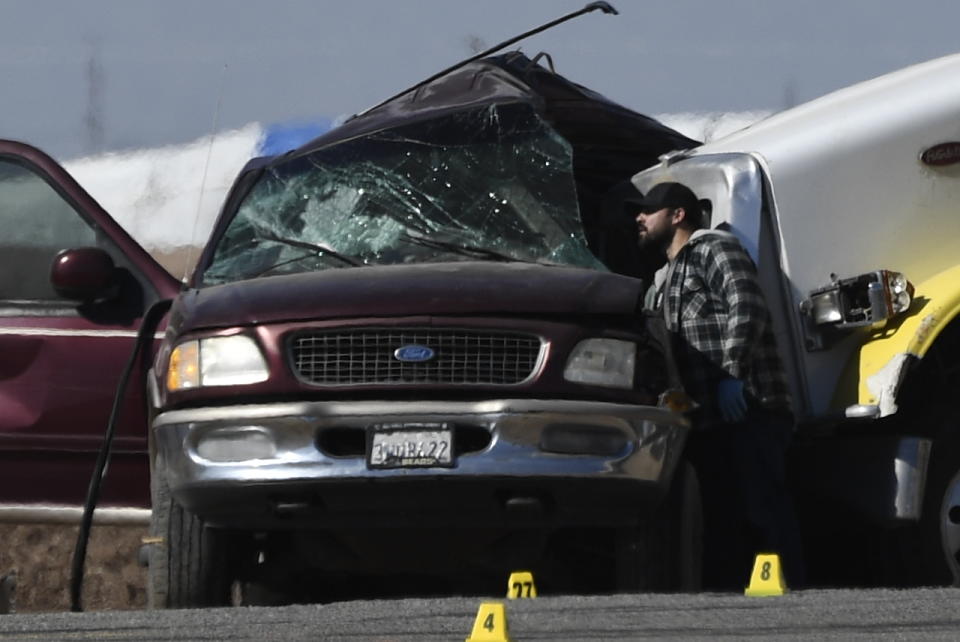 Investagators look over the scene of a crash between an SUV and a semi-truck full of gravel near Holtville, California on March 2, 2021. - At least 13 people were killed in southern California on Tuesday when a vehicle packed with passengers including minors collided with a large truck close to the Mexico border, officials said. (Photo by Patrick T. FALLON / AFP) (Photo by PATRICK T. FALLON/AFP via Getty Images)