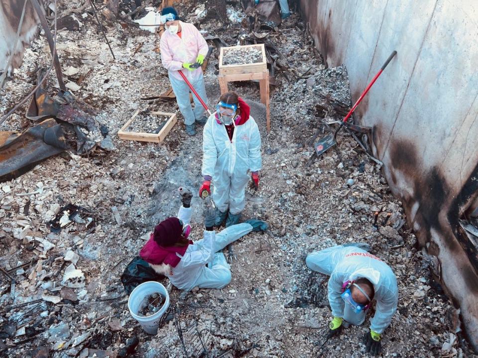 Kate Baer with Stephanie Baer and volunteers searching through remains and ashes of her former home in Superior, Colorado on Jan 9, 2022.