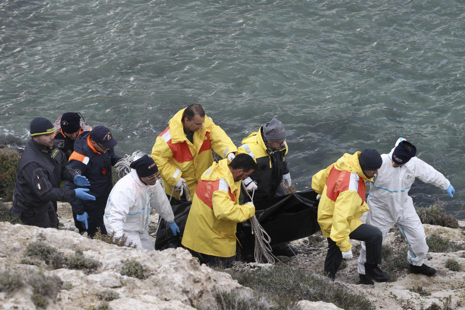 Rescuers carry a body recovered at sea near the Sicilian island of Lampedusa, southern Italy, Sunday, Nov. 24, 2019. Italian news reports say the Italian coast guard has recovered seven bodies of migrants near Lampedusa and kept up its search Sunday of rough seas for as many as 13 other migrants feared missing after their boat capsized on Saturday. (AP Photo/Mauro Seminara)