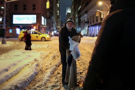 A homeless man smiles after he receives a hot meal and donated clothing as New York City's Coalition for the Homeless delivers food, donated clothing and supplies to homeless people as part of their weekly distribution during winter storm Grayson in Manhattan, New York City, U.S., January 4, 2018. REUTERS/Amr Alfiky