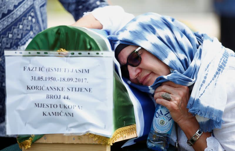 Bosnian Muslims attend a collective funeral in Kamicani