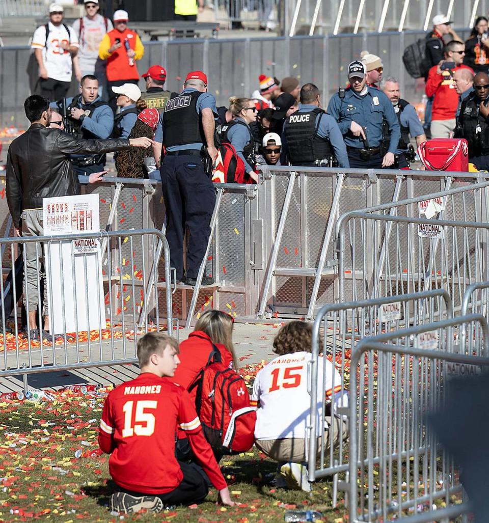 Young Chiefs fans crouch down while several law enforcement officers respond to part of the shooting activity after the Kansas City Chiefs Super Bowl LVIII championship rally on Wednesday, Feb. 14, 2024, at Union Station.