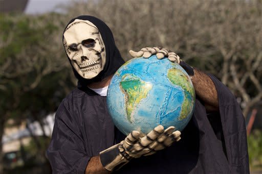 A man representing death holds a globe during a protest outside the People's Summit for Social and Environmental Justice in defense of the commons, a parallel event taking place alongside the United Nations Conference on Sustainable Development, or Rio 20, in Rio de Janeiro, Brazil, Friday, June 15, 2012. (AP Photo/Silvia Izquierdo)