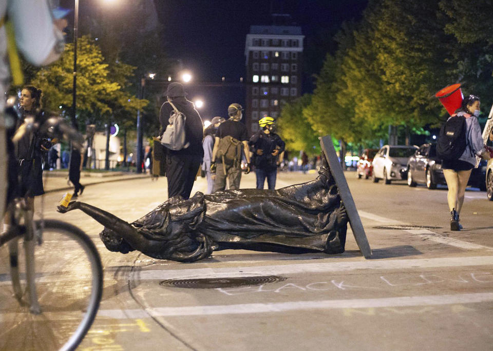 FILE - In this June 23, 2020 file photo, Wisconsin's "Forward" statue lies in the street on Capitol Square in Madison, Wis. Demonstrators who toppled statues this week honoring Hans Christian Heg, a Civil War abolitionist, and the state's "Forward" motto say they went after the sculptures because they wanted to shatter a false narrative that the state and the city support Black people and have achieved racial equity. (Emily Hamer/Wisconsin State Journal via AP File)