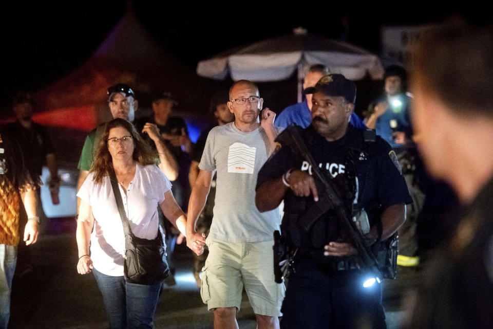 FILE - In this July 28, 2019, file photo, police officers escort people from Christmas Hill Park following a deadly shooting during the Gilroy Garlic Festival, in Gilroy, Calif. In the days and weeks since three high-profile shootings took the lives of more than two dozen people in just a week's time, law enforcement authorities have reported seeing a spike in the number of tips they are receiving from concerned relatives, friends and co-workers of people who appear bent on carrying out the next mass shooting. (AP Photo/Noah Berger, File)