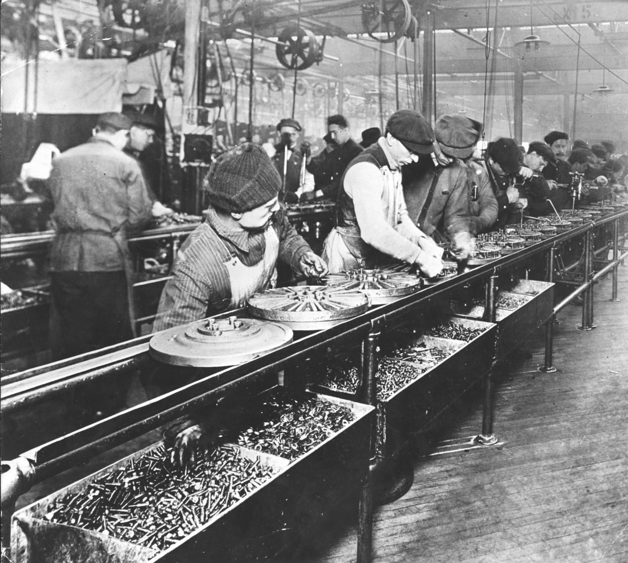 Some workers at the assembly line, making fly wheels for the Ford Model T car in Highland Park Ford Plant. Highland Park, 1914 (Photo by Mondadori Portfolio\Mondadori via Getty Images)