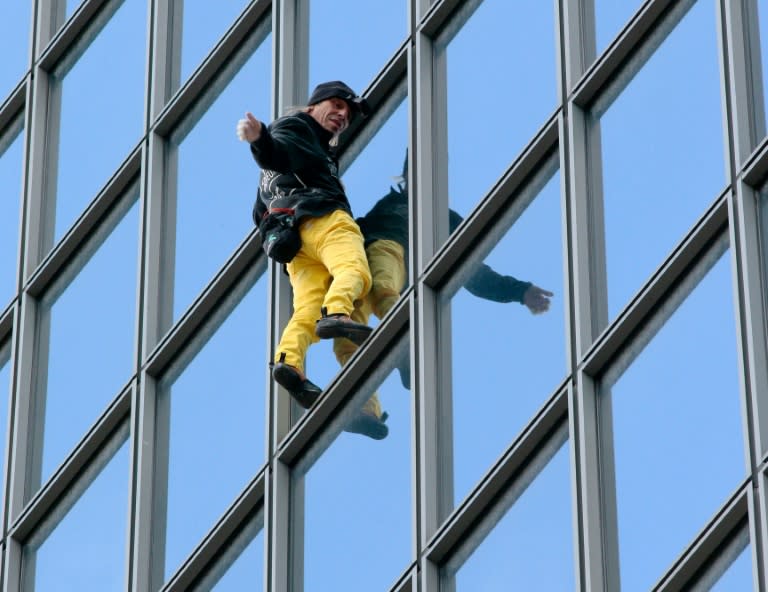 French urban climber Alain Robert scales a building in Paris's La Defense business district on March 21, 2016