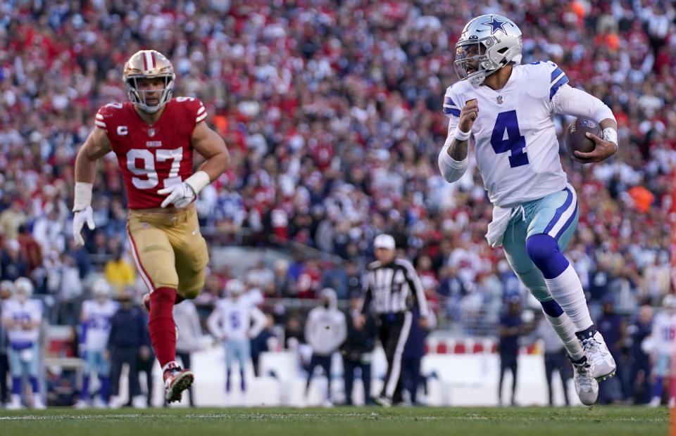 Cowboys QB Dak Prescott scrambles as the 49ers' Nick Bosa pursues.