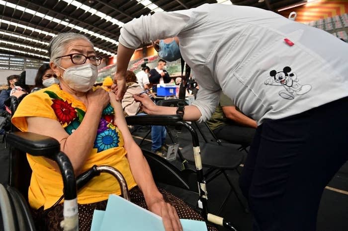 An elderly woman receiving a shot