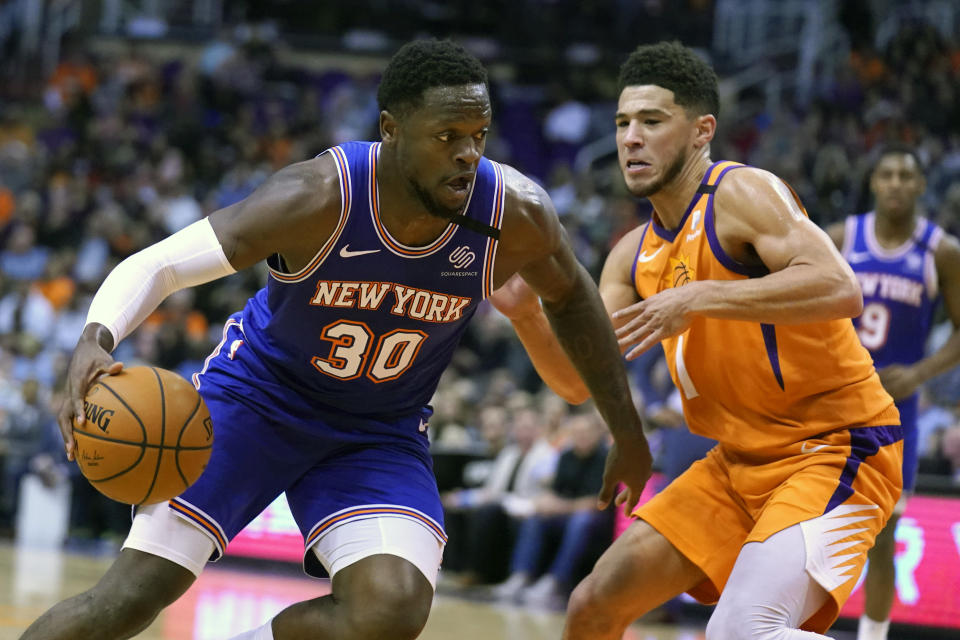 New York Knicks forward Julius Randle (30) drives against Phoenix Suns guard Devin Booker in the first half during an NBA basketball game, Friday, Jan. 3, 2020, in Phoenix. (AP Photo/Rick Scuteri)