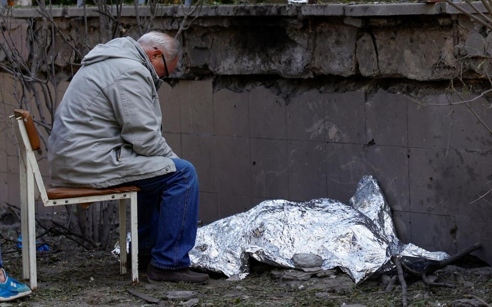 A man mourns over the body of his granddaughter - Reuters/Valentyn Ogirenko
