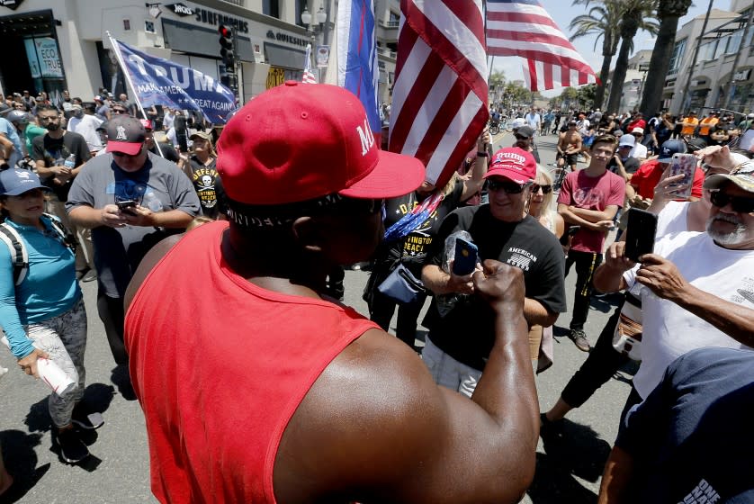 HUNTINGTON BEACH, CALIF. - JUNE 6, 2020. Pro-Trump counterprotesters gather across Pacific Cioast Highway from Black Lives protesters during a demonstration in Huntington Beach on Saturday, June 6, 2020. Black Lives Matter protests continued throughout Southern California on Saturday, more than a week after a black man named George Floyd was killed by police in Minneapolis. (Luis Sinco/Los Angeles Times)