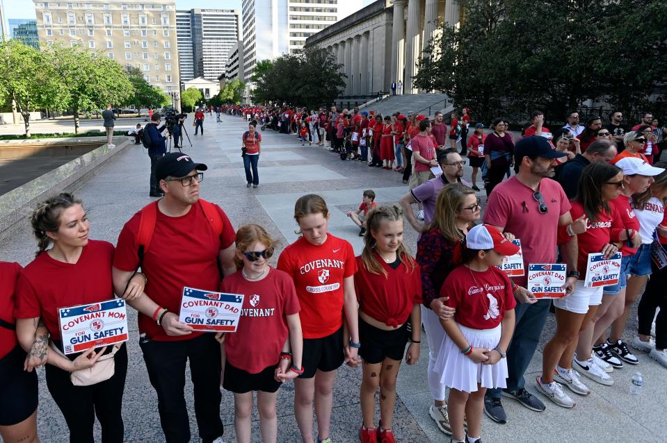 Covenant School families lock arms and hold hands to demonstrate for gun safety and common sense gun laws as part of a three-mile human chain from the Monroe Carell Jr. Children’s Hospital at Vanderbilt to the Tennessee State Capitol Tuesday, April 18, 2023, in Nashville, Tenn. 