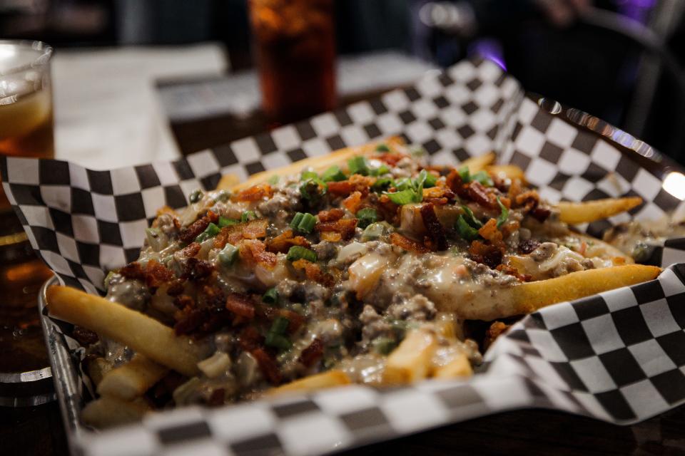 Remi's Arcade & Bistro's Oh, So... You Want Special Fries features fries topped with queso, bacon and green onions.