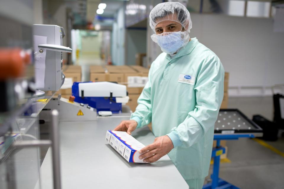 A Pfizer employee holds the final boxes of Paxlovid after the tablets have gone through the company's automated packaging process.