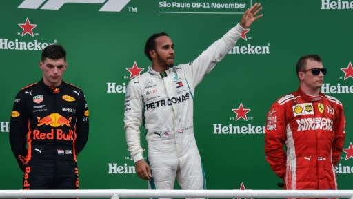 Lewis Hamilton celebrates as a rueful Max Verstappen looks on